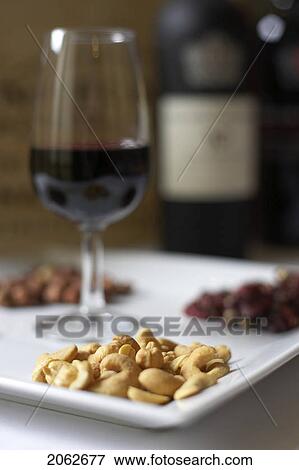 Glass Of Red Wine Presented On A Platter With A Variety Of Nuts View Large Photo Image Stock Photo - Glass Of Red Wine Presented On A Platter With A Variety Of Nuts. Fotosearch