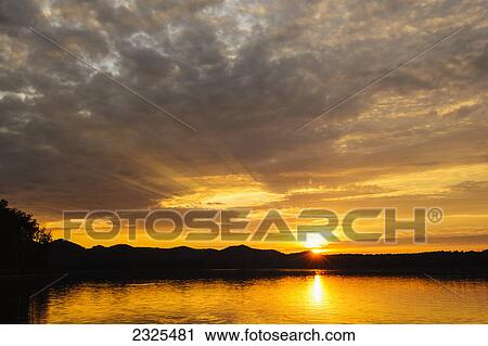 Stock Image - Golden sunlight reflecting on cave run lake at sunset; Morehead kentucky united states of america. Fotosearch