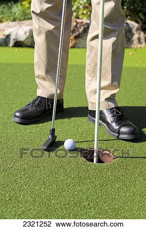 Stock Image - Golfer Putting Next To The Hole; Kissimmee Florida United States Of America. Fotosearch