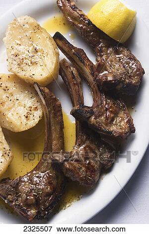 Stock Photo - Grilled lamb chops with oven roasted potatoes. Fotosearch