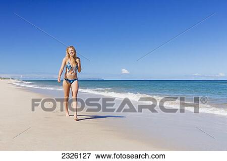 Hawaii, Kauai, Polihale Beach, Young woman walking along beach. View Large Photo Image Stock Photo - Hawaii, Kauai, Polihale Beach, Young woman walking along beach.. Fotosearch