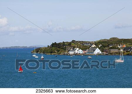 Stock Image - Houses along the coast and boats in the water; Crookhaven county cork ireland. Fotosearch