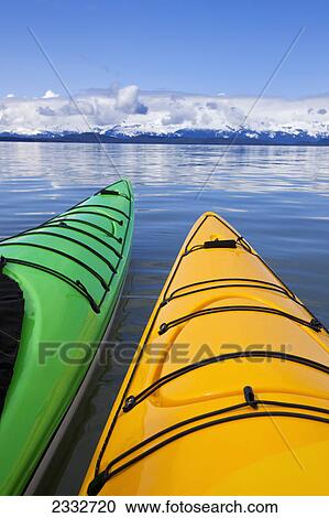 Stock Image - Kayaks on the tranquil water in lynn canal with the chilkat mountains in the distance; Alaska united states of america. Fotosearch