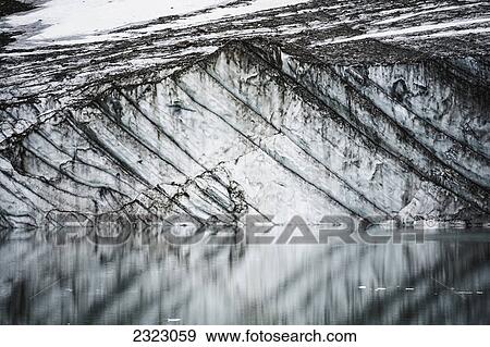 Layers in gravelly glacier cliff reflected in a small glacial lake jasper national park; Alberta canada View Large Photo Image Stock Photo - Layers in gravelly glacier cliff reflected in a small glacial lake jasper national park; Alberta canada. Fotosearch