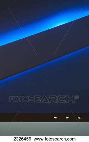 Stock Photograph - Lights along a blue wall in the virgin atlantic lounge heathrow airport; London england. Fotosearch