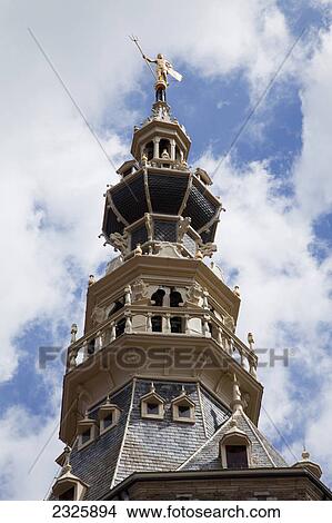 Picture - Low angle view of a multi-level tower on a church with a statue on top; Zierikzee zealand netherlands. Fotosearch