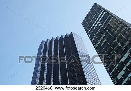 Stock Photo - Low angle view of two skyscrapers against a blue sky with a facade like steps; New york city new york united states of america. Fotosearch