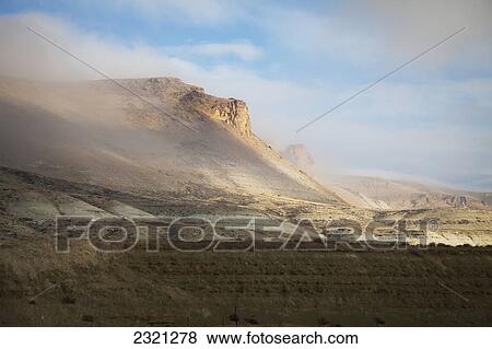 Stock Photo - Low-Lying Clouds Sweep Past Barren Bluff; Wyoming United States Of America. Fotosearch