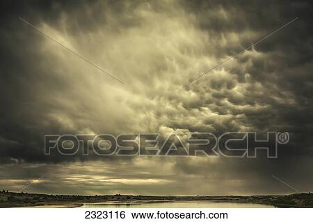 Stock Photograph - Mammatus storm clouds above a lake in the saskatchewan prairies; Saskatchewan canada. Fotosearch
