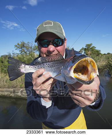 Stock Image - Man holding a redfish (sciaenops ocellatus); Venice louisiana united states of america. Fotosearch