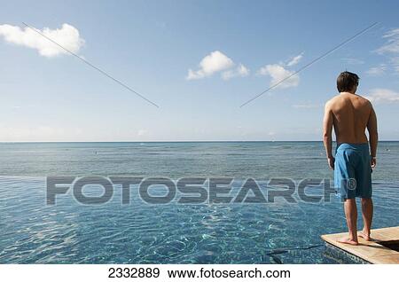 Stock Photo - Man looking at the ocean; Waikiki oahu hawaii united states of america. Fotosearch