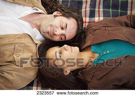 Married couple laying on a blanket facing one another; Edmonton alberta canada View Large Photo Image Stock Photo - Married couple laying on a blanket facing one another; Edmonton alberta canada. Fotosearch