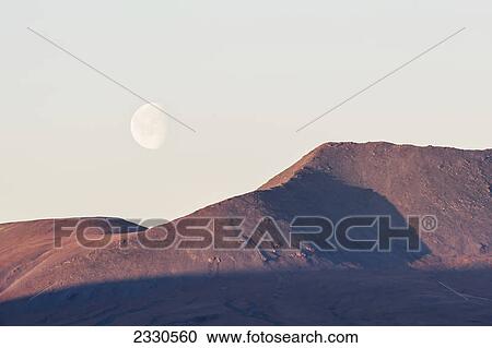 Stock Image - Moon in the sky and brooks range gates of the arctic national park northwestern alaska; Alaska united states of america. Fotosearch