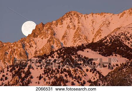 Stock Image - Moonset At Sunrise Over The Sierra Mountains Near Bishop, California. Fotosearch