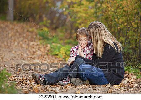 Stock Image - Mother and son talking on a path in a park in autumn; Edmonton alberta canada. Fotosearch