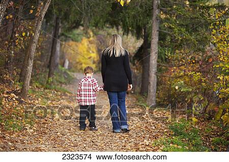 Mother and son walking on a path in a park in autumn; Edmonton alberta canada View Large Photo Image Picture - Mother and son walking on a path in a park in autumn; Edmonton alberta canada. Fotosearch