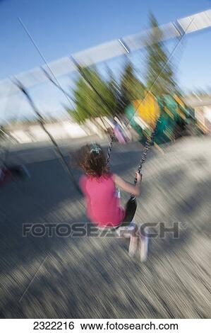 Motion blur of a young girl swinging at the school playground; Anchorage alaska united states of america View Large Photo Image Stock Photograph - Motion blur of a young girl swinging at the school playground; Anchorage alaska united states of america. Fotosearch