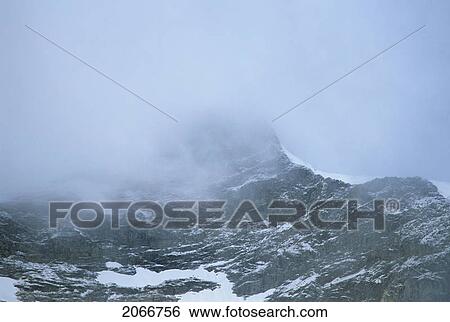Mountain Ridge With Cloud Cover And Snow Patched, Athabasca Pass, Jasper National Park View Large Photo Image Stock Photograph - Mountain Ridge With Cloud Cover And Snow Patched, Athabasca Pass, Jasper National Park. Fotosearch