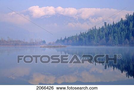 Stock Photograph - One Mile Lake, Near Pemberton, Bc In Early Morning Mist. Fotosearch