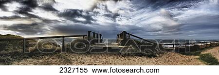 Stock Photography - Panoramic view of a boardwalk and fence on a beach at hengistbury head; Dorset england. Fotosearch