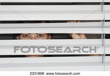 Stock Photo - Peeking out the slats of a window covering; Locarno ticino switzerland. Fotosearch