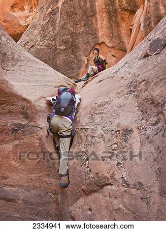 Stock Image - People exploring a slot canyon; Hanksville utah united states of america. Fotosearch