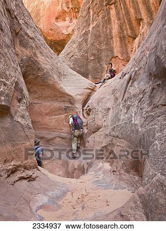 Stock Photo - People exploring a slot canyon; Hanksville utah united states of america. Fotosearch
