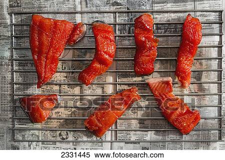 Stock Photography - Pieces of kenai river red sockeye salmon sitting on drying racks in preparation for putting them in a smoker; Anchorage alaska united states of america. Fotosearch