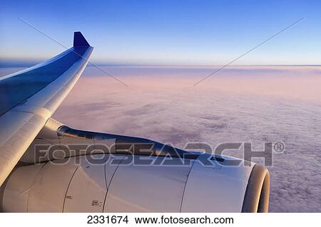 Picture - Plane flying over clouds. Fotosearch
