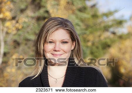 Stock Image - Portait of a young woman in a park in autumn; Edmonton alberta canada. Fotosearch
