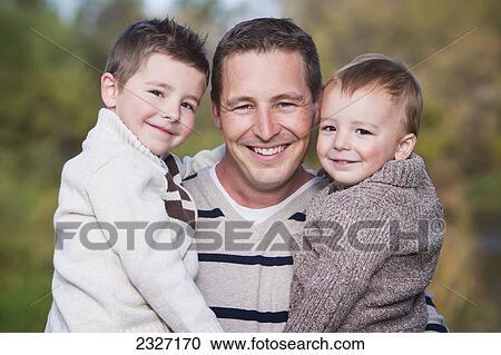 Stock Image - Portrait of a father and two young sons; St. albert alberta canada. Fotosearch