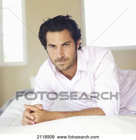 Portrait Of A Man Laying On A Bed; Wailua Kauai Hawaii United States Of America View Large Photo Image Stock Photo - Portrait Of A Man Laying On A Bed; Wailua Kauai Hawaii United States Of America. Fotosearch