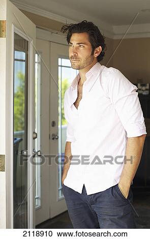 Stock Image - Portrait Of A Man Standing By An Open Door; Wailua Kauai Hawaii United States Of America. Fotosearch