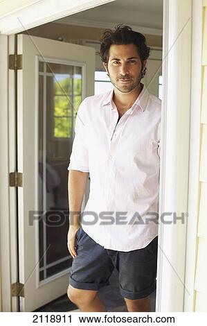 Stock Image - Portrait Of A Man Standing In An Open Doorway; Wailua Kauai Hawaii United States Of America. Fotosearch