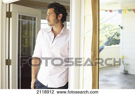 Stock Image - Portrait Of A Man Standing In An Open Doorway; Wailua Kauai Hawaii United States Of America. Fotosearch