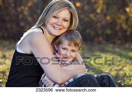 Stock Photograph - Portrait of a mother and son in a park in autumn; Edmonton alberta canada. Fotosearch