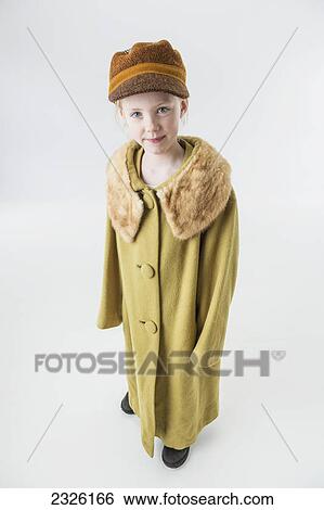 Portrait of a young girl dressed in an oversized coat on a white background; Anchorage alaska united states of america View Large Photo Image Stock Photograph - Portrait of a young girl dressed in an oversized coat on a white background; Anchorage alaska united states of america. Fotosearch