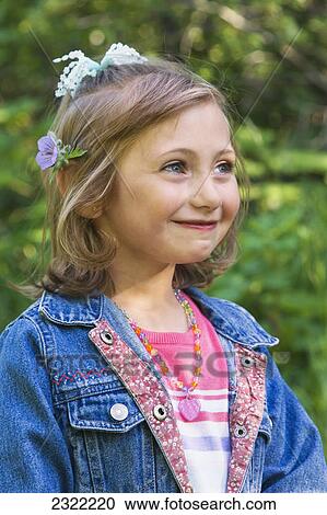 Stock Image - Portrait of a young girl with flower accessories in her hair; Anchorage alaska united states of america. Fotosearch