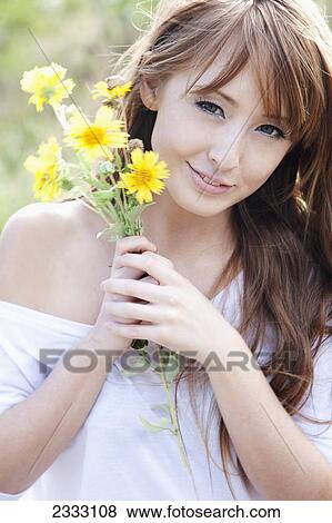 Portrait of a young woman holding a bouquet of yellow flowers; Honolulu oahu hawaii united states of america View Large Photo Image Stock Photo - Portrait of a young woman holding a bouquet of yellow flowers; Honolulu oahu hawaii united states of america. Fotosearch
