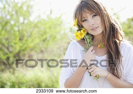 Portrait of a young woman holding a bouquet of yellow flowers; Honolulu oahu hawaii united states of america View Large Photo Image Stock Photo - Portrait of a young woman holding a bouquet of yellow flowers; Honolulu oahu hawaii united states of america. Fotosearch