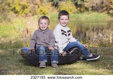 Stock Image - Portrait of two young boys in a park in autumn; St. albert alberta canada. Fotosearch