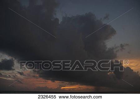 Stock Photography - Rain cloud during a stormy sunset; Ranveli island south ari atoll maldives. Fotosearch