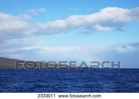 Stock Image - Rainbow over coastline; Lanai hawaii united states of america. Fotosearch