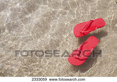 Stock Photo - Red beach slippers floating in the ocean; Honolulu oahu hawaii united states of america. Fotosearch