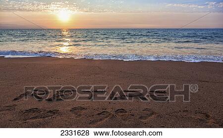 Retire is written in the sand on a tropical beach as the sun sets; Puerto vallarta mexico View Large Photo Image Stock Photo - Retire is written in the sand on a tropical beach as the sun sets; Puerto vallarta mexico. Fotosearch
