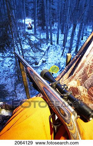 Stock Photo - Rifle Rests On Knee Of Hunter, Atv Approaching In Distance, Alberta. Fotosearch
