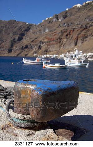 Stock Photo - Ropes tied at shore and boats mooring in the harbour; Manola greece. Fotosearch