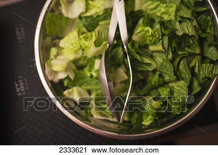 Salad in a bowl with serving tongs View Large Photo Image Stock Image - Salad in a bowl with serving tongs. Fotosearch