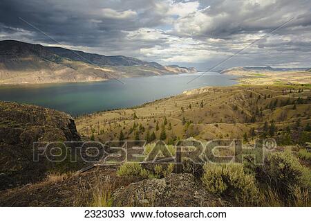 Stock Image - Scattered clouds over kamloops lake and the dry hills surrounding it; Kamloops british columbia canada. Fotosearch