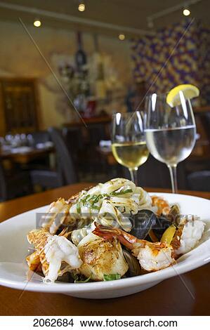 Picture - Seafood Dish With White Wine And Glass Of Water In Restaurant Setting. Fotosearch